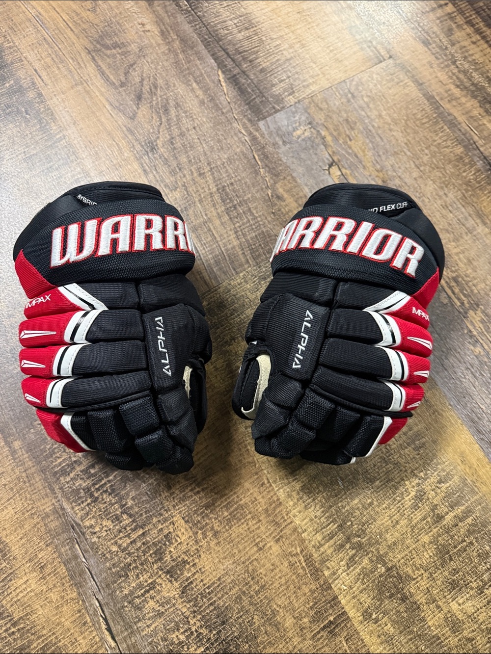 Warrior Alpha Youth Hockey Gloves in Black and Red